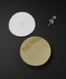 Wood disk, paper guide, and a push pin.